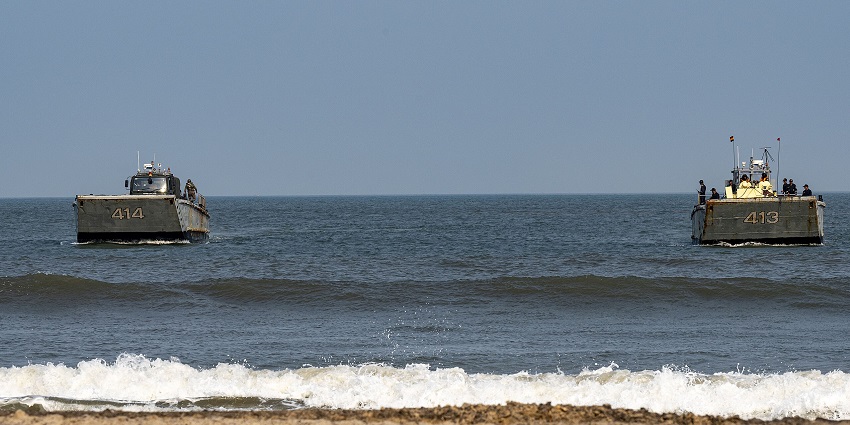 A picture of navy ships cruising in the sea as seen from the shore of Kakinada Beach