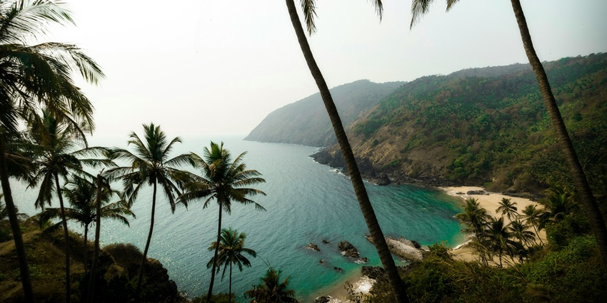 Serene Kakolem Beach, lined with palm trees and beach shacks offering refreshments.