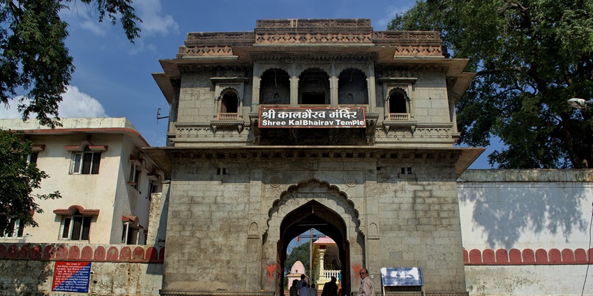 The entrance of Kal Bhairav Temple in Ujjain, featuring a grand archway adorned with intricate carvings and statues.