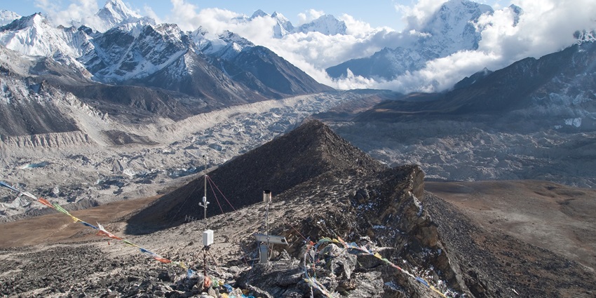 Snow-covered Kala Patthar mountain in Nepal, with a clear blue sky and rugged terrain.