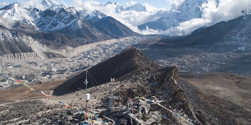 A rugged, snow-capped Kala Patthar mountain peak under a clear blue sky