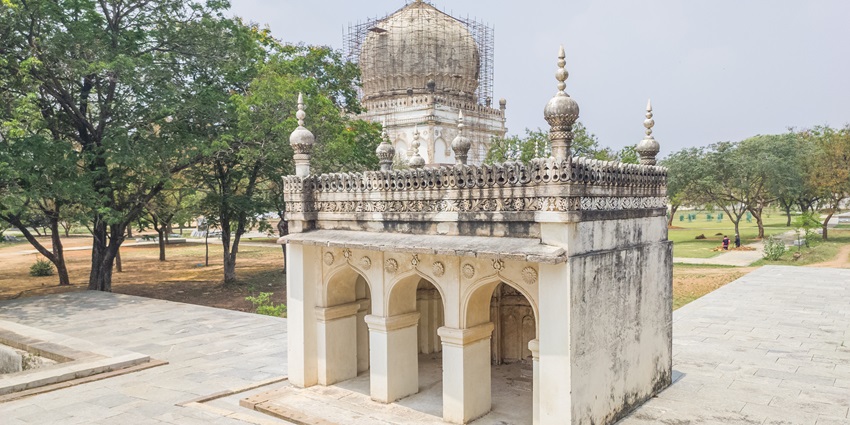 A picture of a historical tomb located in Karnal, surrounded by green gardens all around