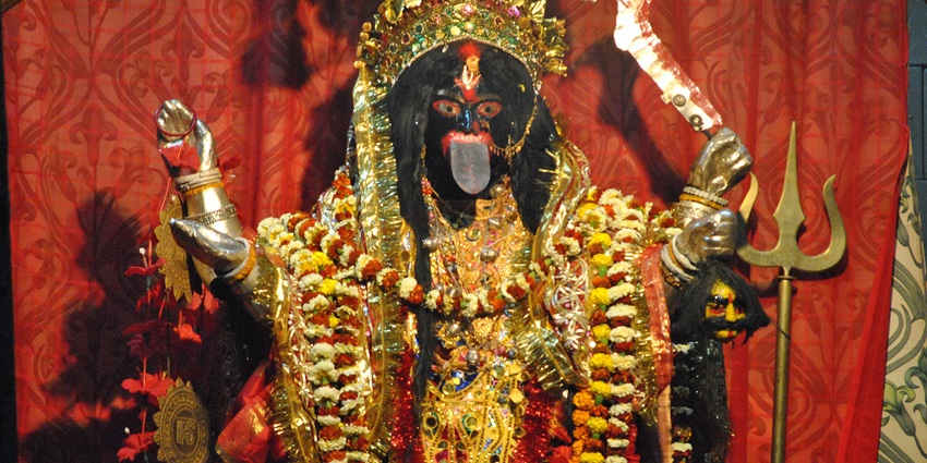 An image of the close-up of the idol of Goddess Kali adorned with flowers and garlands.