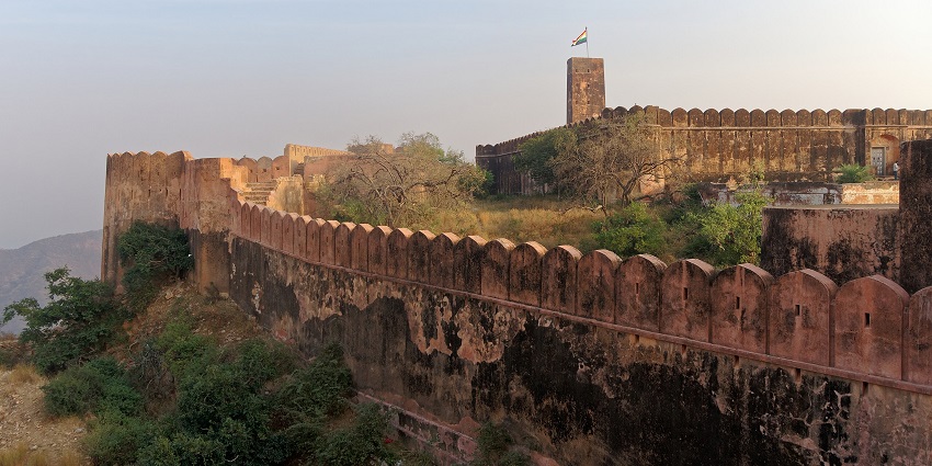 A picture of a majestic fort in Katni, with tall exterior walls, surrounded by greenery
