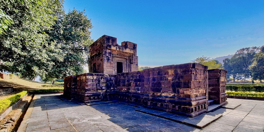 View of the Kamtaji Temple courtyard surrounded by lush greenery