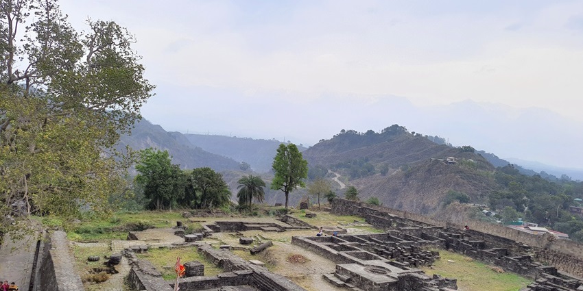 A breathtaking aerial view of the Kangra Fort surrounded by views of lush green meadows.