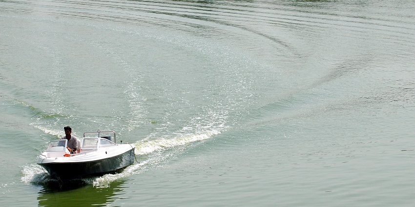 A man riding a motorboat through the waves of Kankaria Lake, one of the places near this museum