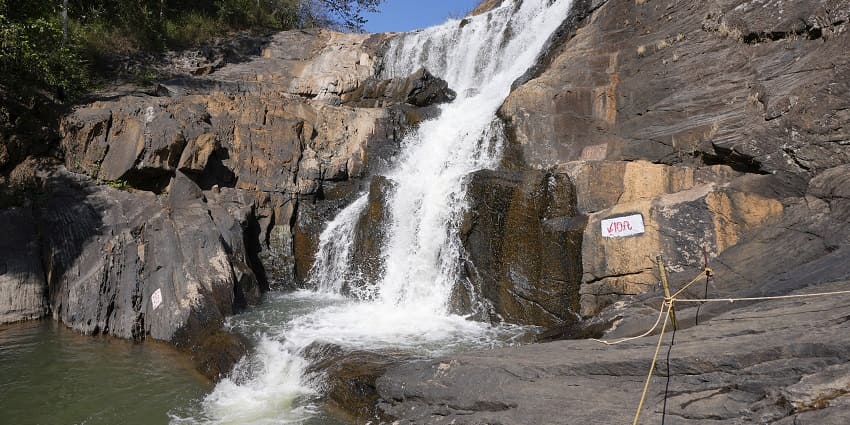 A picture of a waterfall slowly cascading down a hilly and rocky terrain