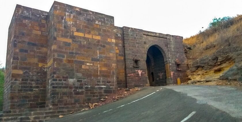 View of the entrance of the Kanthkot Fort in Gujarat, surrounded by hills and greenery.