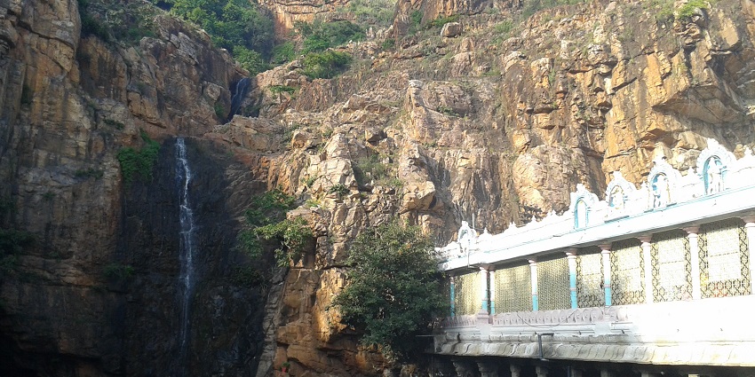 Image of Kapila Theertham Temple near the waterfall cascading through big rocks during day time