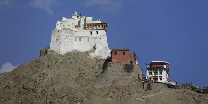 A mesmerising view of a monastery perched on top of a rocky hill during the daytime.