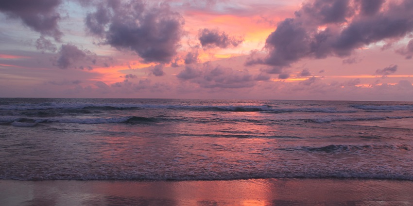 A picture of a beautiful sunset at Karon Beach in Phuket with pink hues all around