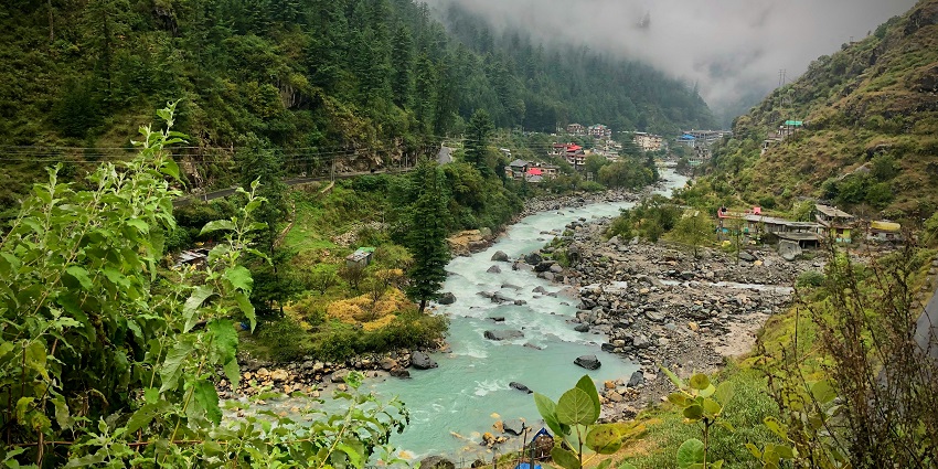 Image of Kasuli with river surrounded by lush green mountains and houses on top