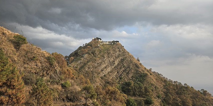 Beautiful view of a house on top of the mountains found in Kasauli under cloudy sky