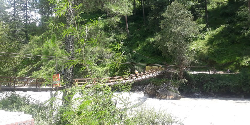 A picture of a water body around the green terrains for trekking in the Kheer Ganga region