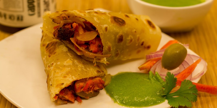 Close up shot of Chicken Kathi roll served with mint chutney, a popular delicacy