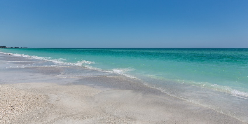 An enchanting view of glistening waters meeting the pristine golden sands of Kaup.