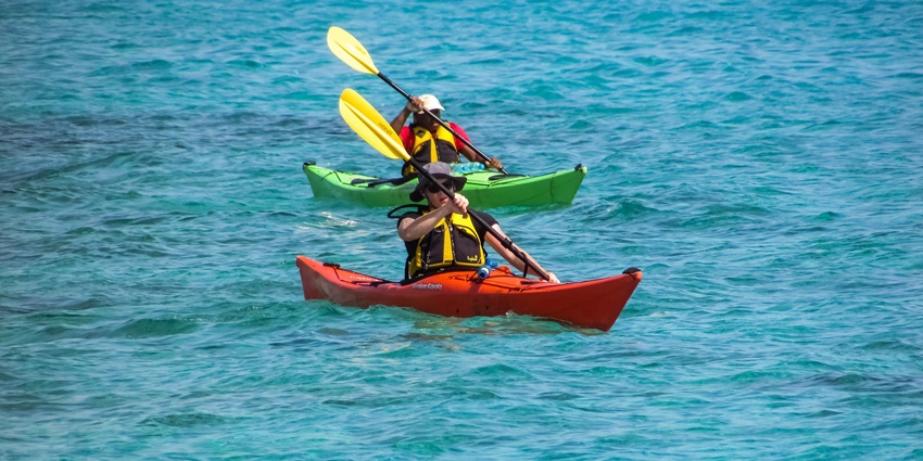 A breathtaking view of two people enjoying on a kayak in the middle of a body of water.