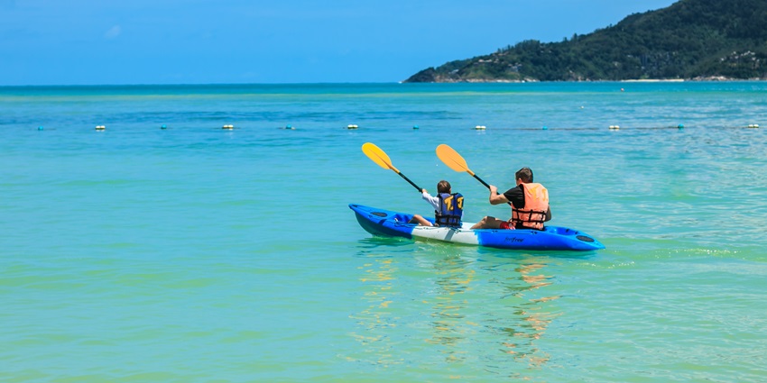 View of two tourists kayaking from the shores of the beach