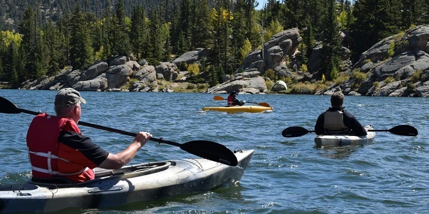 An image representing three men riding Kayaks on a body of water, one of the laid-back experiences.