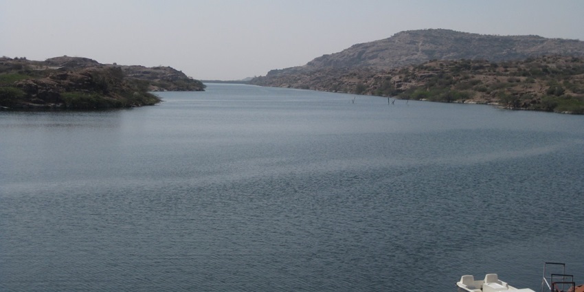 An idyllic view of the Kaylana Lake featuring shimmering blue waters and greenery.