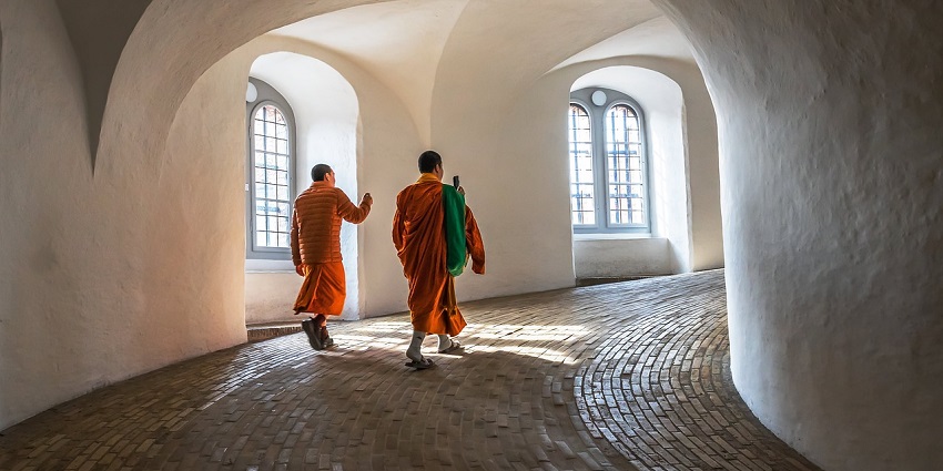 Monks and tourists at a tower, reminiscent of cultural sights near Sakteng Sanctuary.