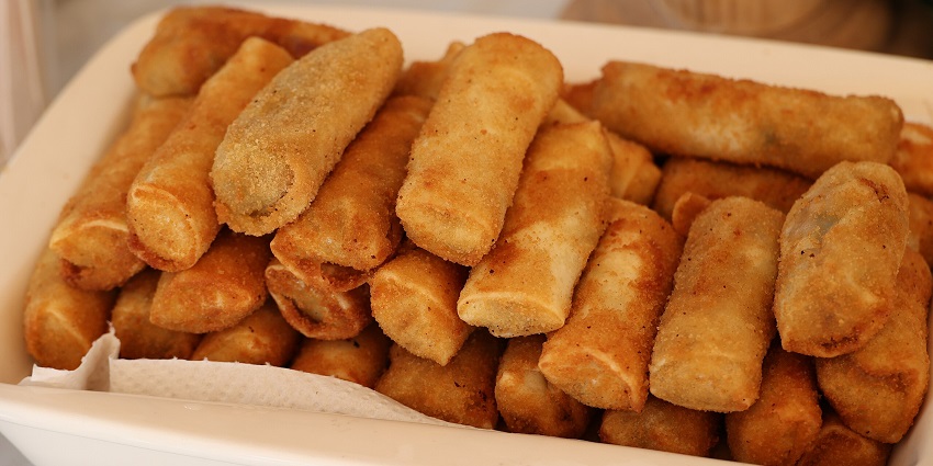 mage of chicken rolls served on a plate with a side of fresh vegetables and dipping sauce