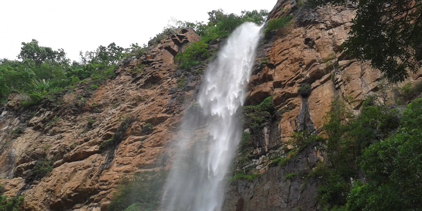 Khandadhar Waterfall in Orissa, with its cascading waters surrounded by lush greenery.