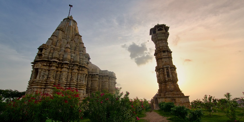 View of Kirti Stambh adjacent to the temple, showcasing its intricately carved stonework.