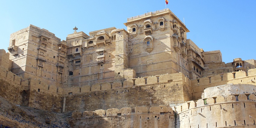 Front view of Kishangarh Fort, displaying its grand architecture and historical significance amidst lush surroundings.