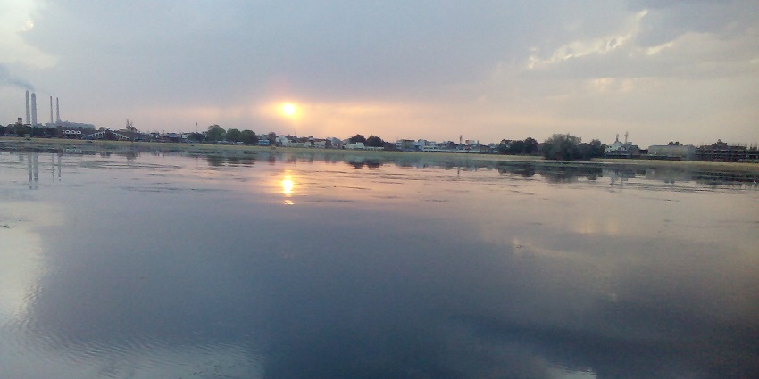 View of Kishore sagar lake, with vibrant sunset hues reflecting in the water