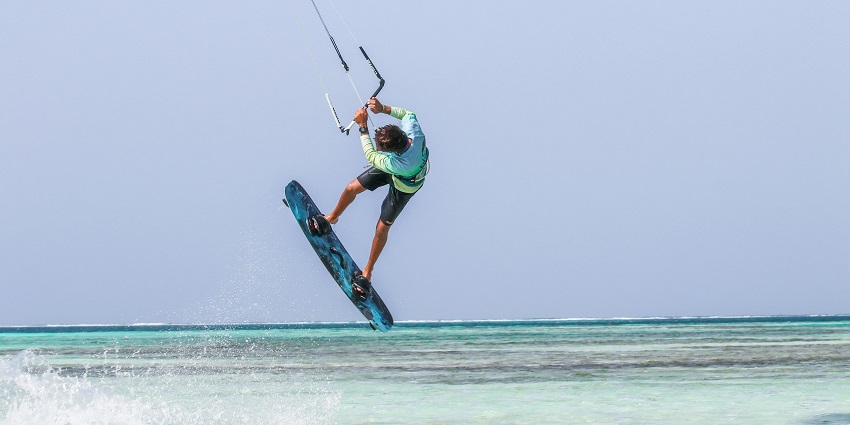 An image of a man performing one of the most popular water sports in Krabi—kitesurfing.