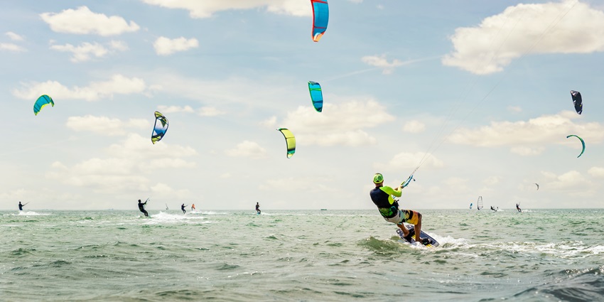 Distant view of a group of people doing kite surfing, one of the most fun water sports in south goa