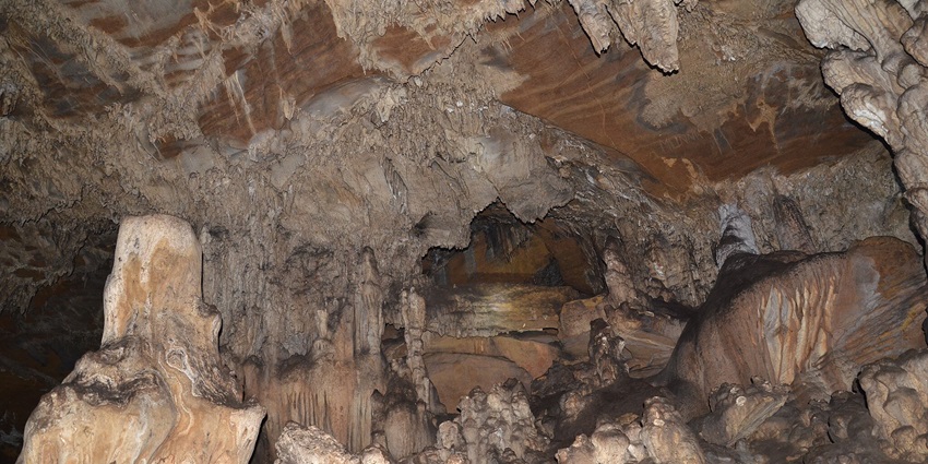 Inside view of the Kutumsar Caves which shows several stalactites and stalagmites.