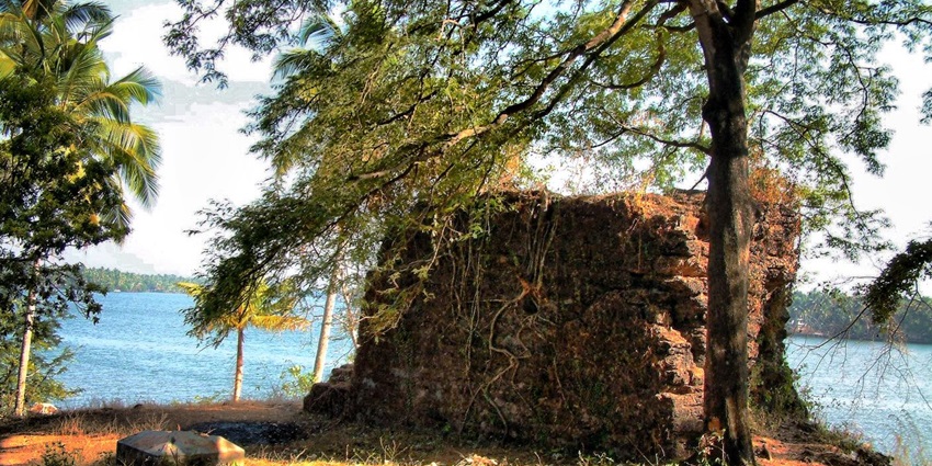 A picture of the ruins of one of the forts in Kerala, with a waterbody in the background