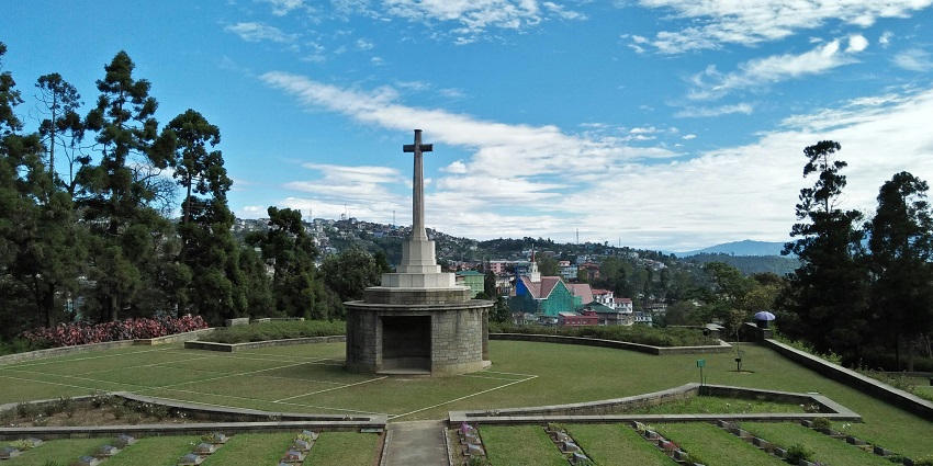A serene view of Kohima War Cemetery, honouring fallen soldiers with lush greenery.