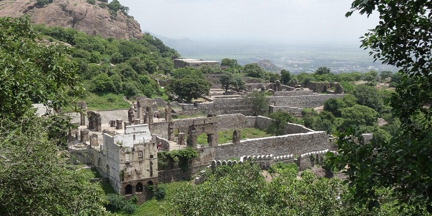 A bird’s eye view of the Kondapalli Kila surrounded by lush green trees and fields.