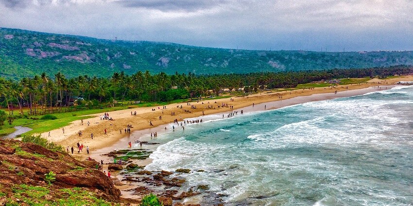 Aerial view of the turquoise waters of the beach with silver waves crashing the golden shores