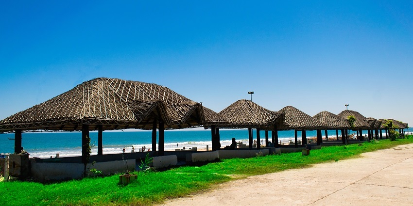 A serene stretch of golden sand with gentle waves and a vibrant sunset - things to do in ongole.