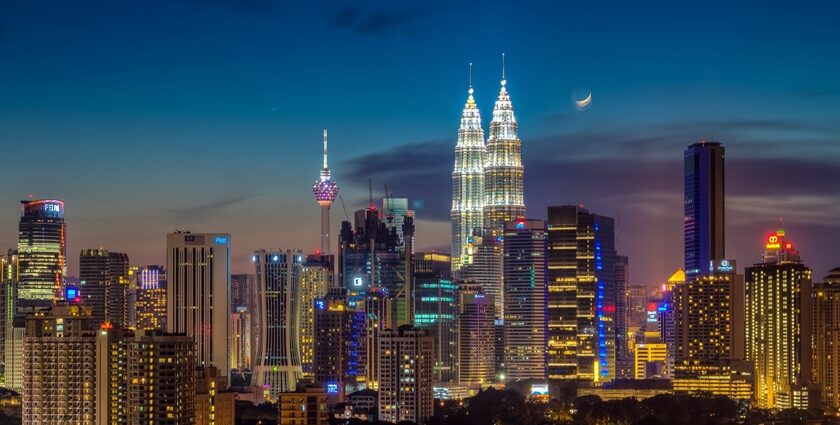 A stunning moonrise over the Kuala Lumpur skyline with the Petronas Towers visible.