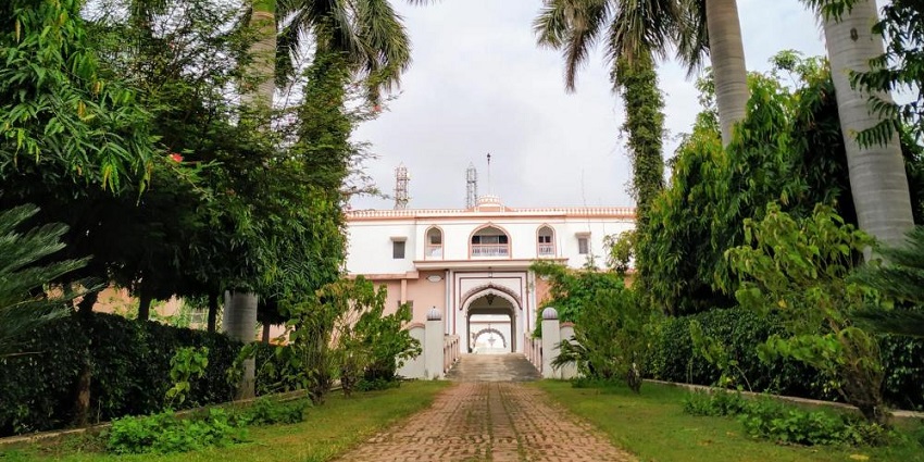 A grand heritage fort with towering structures and lush greenery, offering a glimpse into Mughal and British-era architecture.
