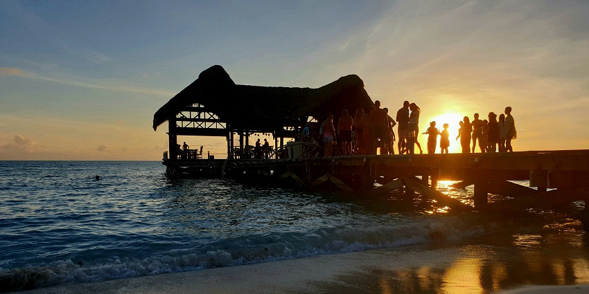 A glimpse of people partying on the beach with the backdrop of the sun settling down.
