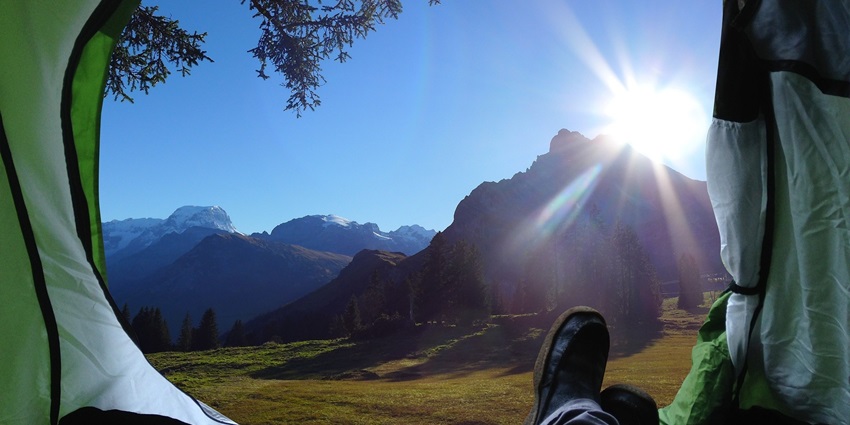 A tent on a hillside for camping in Solan with a panoramic view of mountains and valleys.