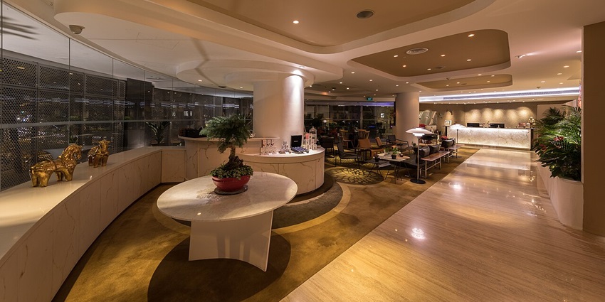 Elegant hotel lounge with curved parquet ceiling, pillars, and central round table