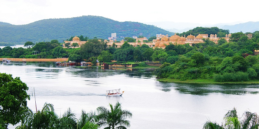 Picturesque view of lake Pichola - a boat on a river near a city, one of the best places to visit
