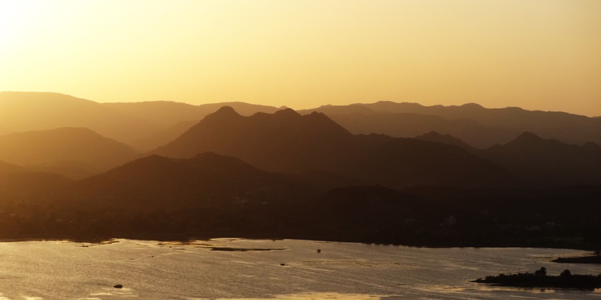 Sunset view over Lake Pichola, the best place to go in Udaipur in October, with calm waters.