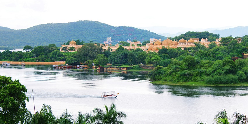 A mesmerising view of the serene waters of Lake Pichola surrounded by lush greenery.