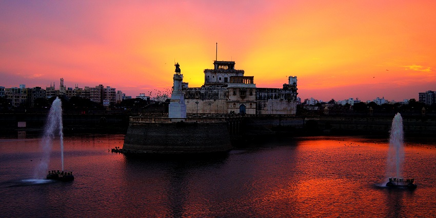 Lakhota lake view and palace surrounded by water at sunset, featuring exquisite fountains.