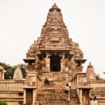 A landscape view of Lakshmana Temple with people sitting on the pavements and around the temple.