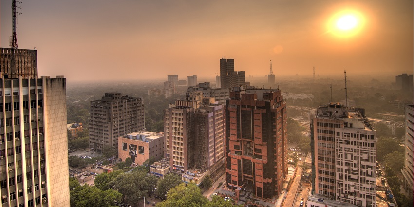 A picture of Delhi's cityscape taken during a sunset with multiple buildings visible